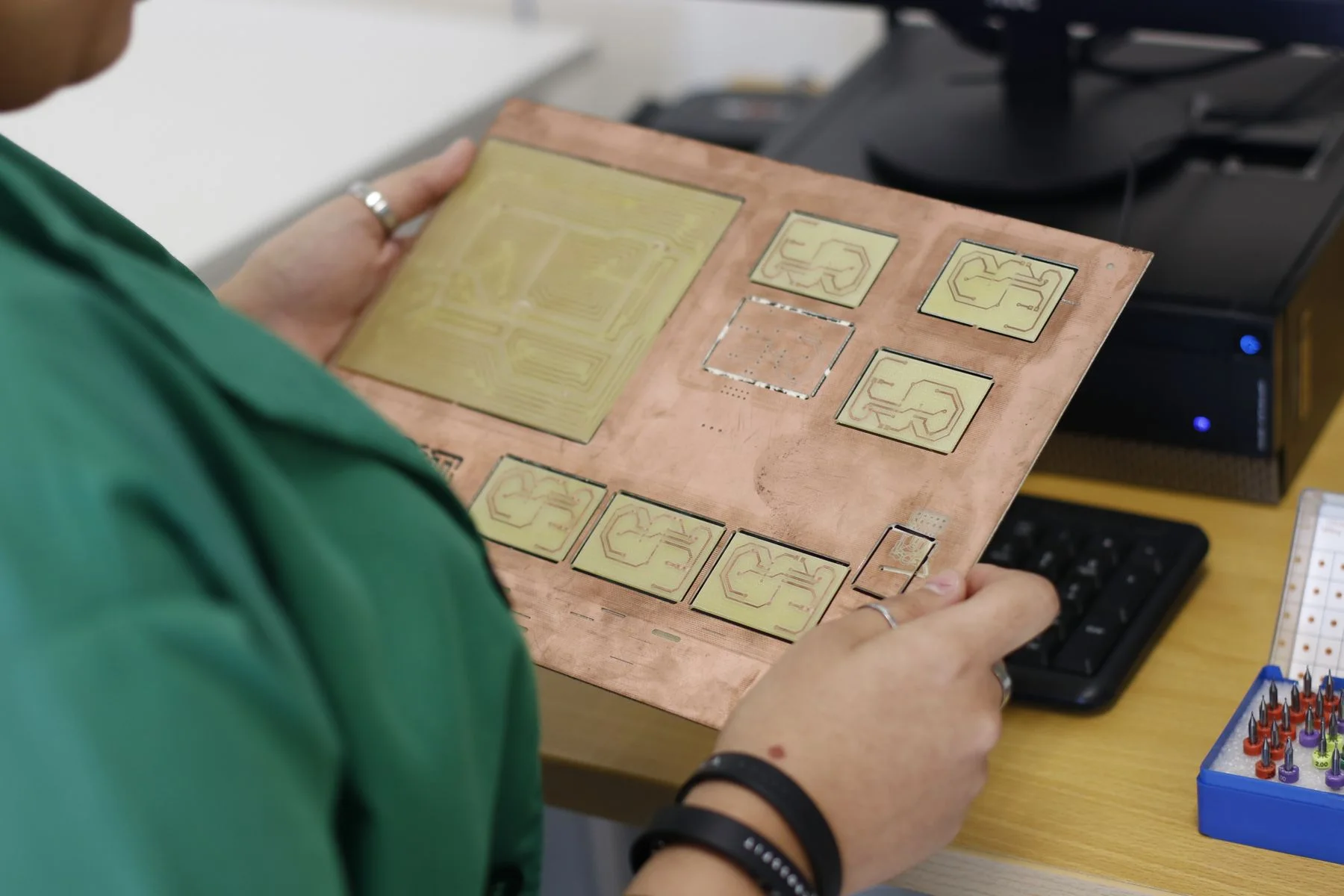 An engineer studies a prototype circuit board in a workshop.