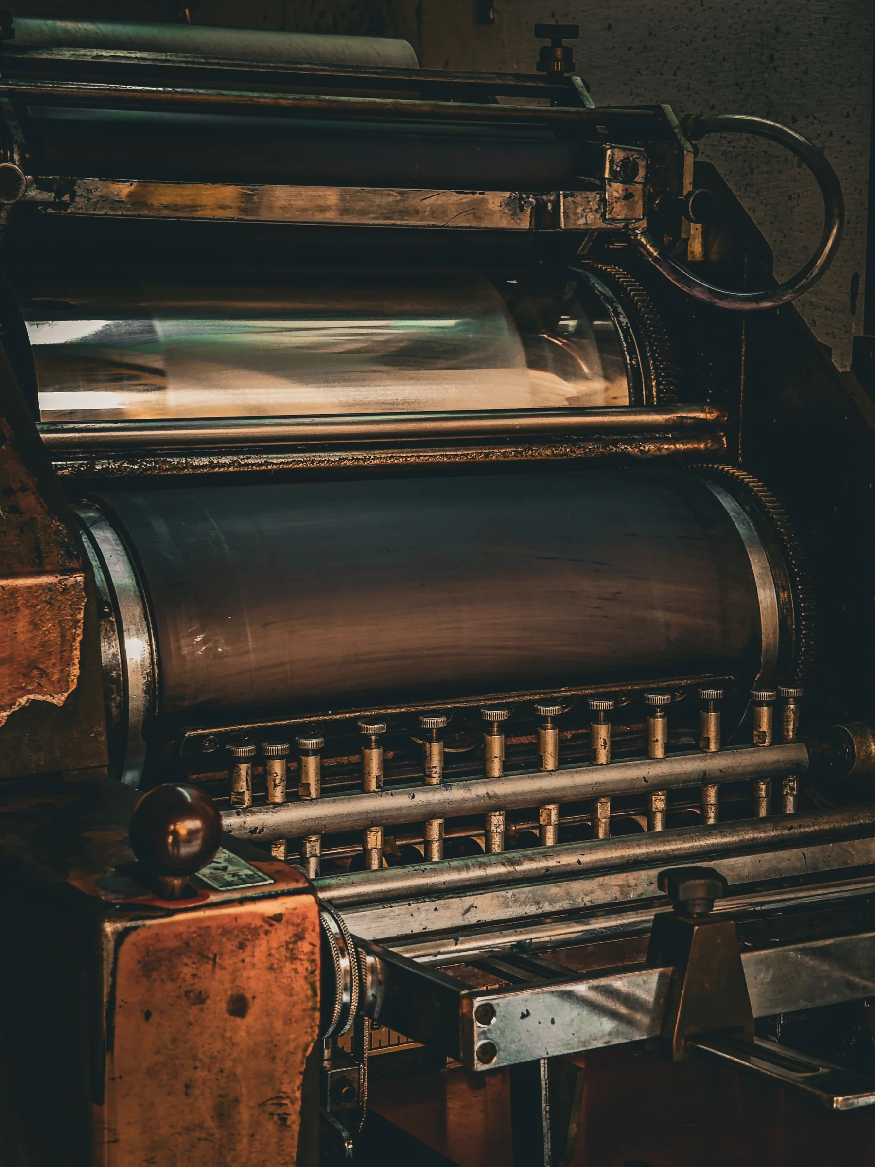 A close view of rollers and mechanisms inside a vintage printing press.