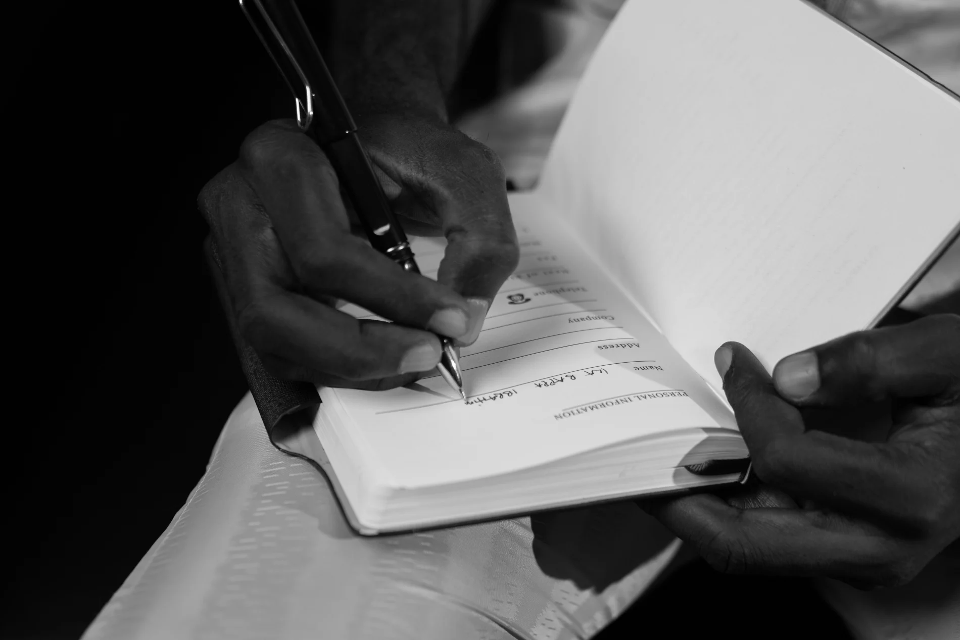Hands writing notes in a paper journal